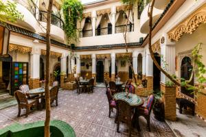 a restaurant with tables and chairs in a courtyard at Riad Olivier Marrakech medina in Marrakesh