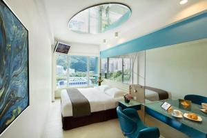 una camera da letto con un letto e una grande finestra di Regal Riverside Hotel a Hong Kong