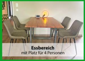 a wooden table with four chairs and a lamp on top at MARKs Ferienwohnung in Bad Sachsa - waldnah, hundefreundlich, ruhig! Ideal für Paare mit Hund in Bad Sachsa