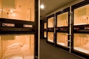 a room with a row of bunk beds in it at Dormy Inn Nagasaki Shinchichukagai in Nagasaki