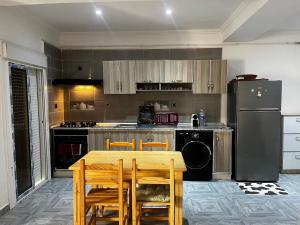 a kitchen with a table and a refrigerator at Spacious and sunny comfy apartment in Oran