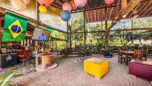 a restaurant with tables and chairs in a room at Pousada Portal do Cacau-Petfriendly in Camburi