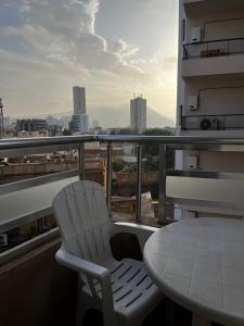 a white chair and a table on a balcony at Spacious and sunny comfy apartment in Oran