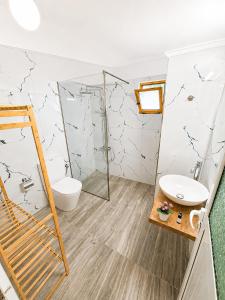 a bathroom with a shower and a toilet and a sink at Vasiliu Boutique Hotel Ksamil in Ksamil +25 photos