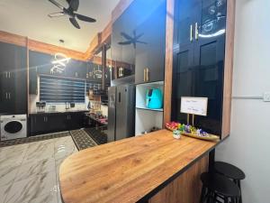 a kitchen with a wooden counter and a refrigerator at Zhara Homestay in Ipoh
