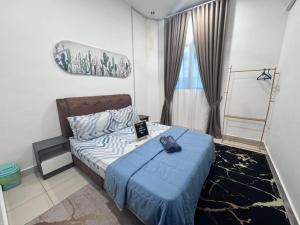 a bedroom with a bed with a blue blanket at Zhara Homestay in Ipoh +10 photos