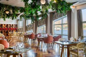 a restaurant with tables and chairs and windows at Four Seasons Cairo At The First Residence in Cairo