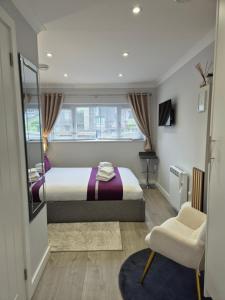 a bedroom with a bed and a chair and a mirror at Pro Stay Studio in Fort William