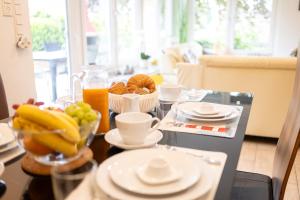 a table with a bowl of fruit and a bowl of orange juice at Robbenglück Tossens - Ruhe, Garten und Nordseegefühl in Tossens