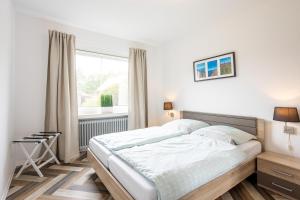 a bedroom with a bed and a window at Robbenglück Tossens - Ruhe, Garten und Nordseegefühl in Tossens