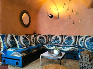a living room with a blue couch and birds on the wall at Riad Vejerísimo - Unique private patio house 8 pers in Vejer de la Frontera