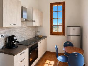 a kitchen with a sink and a table with chairs at Monte Cuccu Bed & Breakfast in Cerfignano +13 photos