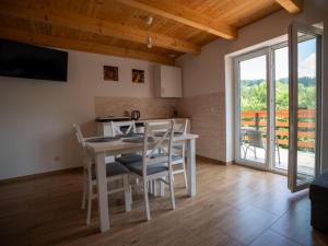 a kitchen and dining room with a table and chairs at Chatki Niwkii u Zbója Studio z antresolą in Krościenko