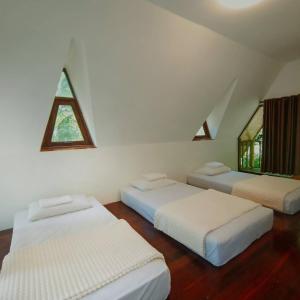 three beds in a room with a window at SN Garden in Ban Bo Hin