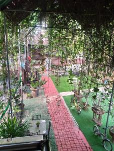 a garden with a red brick walkway and tables and chairs at Sikatel Hotel in Batac