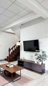 a living room with a tv and a coffee table at Triple T House in Hat Yai