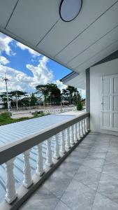 a balcony with a white railing and a window at Triple T House in Hat Yai