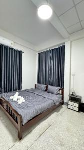 a bedroom with a bed with two white towels on it at Triple T House in Hat Yai +8 photos