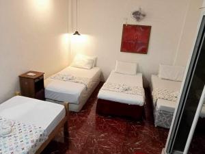 a room with three beds in a room at Sikatel Hotel in Batac