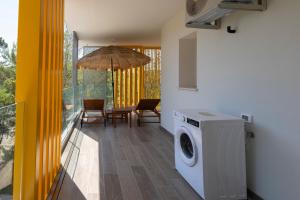 a kitchen with a washing machine and an umbrella at Don Cesar Palace in Bibione