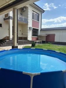 a blue swimming pool in front of a house at Эксклюзивный Дом Самарканда in Samarkand