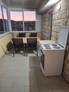 a kitchen with a stove and a table with chairs at Apartment Moki in Lastva