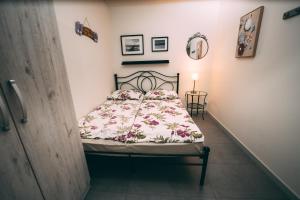 a bedroom with a bed with a floral bedspread at Apartamenty PRIMA in Rewal