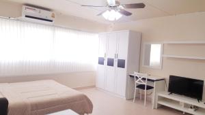 a bedroom with a bed and a desk and a television at Popular Condo C4 in Nonthaburi