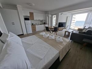 a large white bed in a room with a kitchen at Alee Infinity Pool & Spa in Mamaia Sat/Năvodari +27 photos