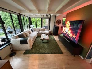 a living room with a couch and a flat screen tv at Vakantiehuis Lanaken in Lanaken