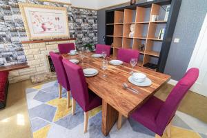 a dining room with a wooden table and purple chairs at Gateway to Gower in Dunvant
