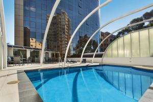 ein Schwimmbad in der Mitte eines Gebäudes in der Unterkunft Novotel Sydney Parramatta in Sydney