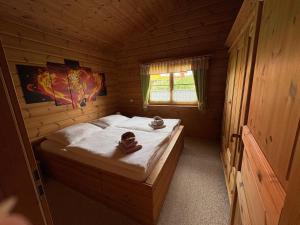 a bedroom with a bed in a wooden cabin at Ferienhaus Hohenlubast in Gräfenhainichen