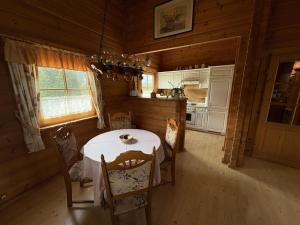 a dining room with a table and a kitchen at Ferienhaus Hohenlubast in Gräfenhainichen +6 photos