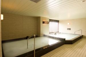 a large bath room with a large bath tub at Dormy Inn Nagasaki Shinchichukagai in Nagasaki