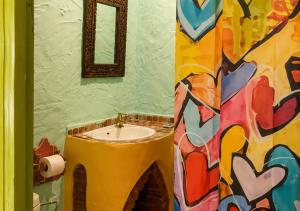a bathroom with a sink with a painting on the wall at Caiat Lounge Refuge , Mountain Lodge near Akchour Waterfalls in Taghzoute