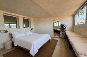 a bedroom with a large white bed and a couch at Pensión Sevillano in Nerja