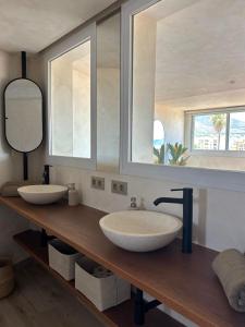a bathroom with two sinks on a wooden counter at Pensión Sevillano in Nerja +30 photos