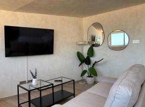 a living room with a couch and a flat screen tv at Pensión Sevillano in Nerja