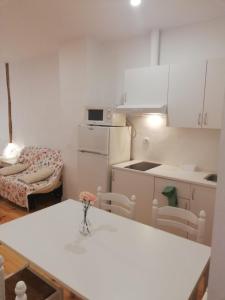 a small white kitchen with a table and chairs at Calle Carmen Céntrico Amplio in Pamplona