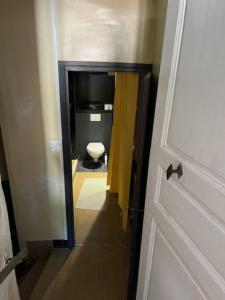 a door to a bathroom with a toilet and a television at Grand appartement de charme avec parking privé in Florac +31 photos