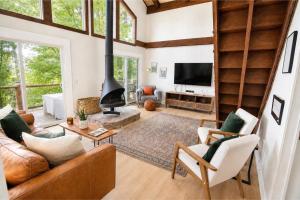 a living room with a couch and a fireplace at Modern Chalet Hot Tub Game Loft 1 Mi to Skiing in Beech Mountain