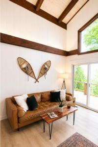a living room with a couch and a butterfly on the wall at Modern Chalet Hot Tub Game Loft 1 Mi to Skiing in Beech Mountain +39 photos