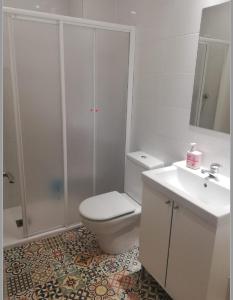 a white bathroom with a toilet and a sink at Calle Carmen Céntrico Amplio in Pamplona