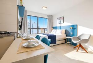 a hotel room with a bed and a table and a kitchen at Allure Residence by Carpediem in Recife