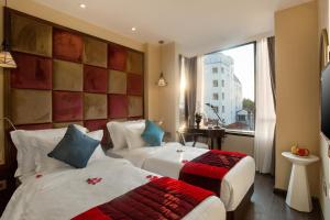 Postel nebo postele na pokoji v ubytování Hanoi La Storia Hotel