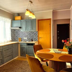 a kitchen with blue cabinets and a table with chairs at Yasmin Apartment in Pärnu