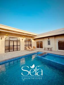a swimming pool in front of a building at Sefa Countryside in Sukhi Sewānia