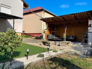 a backyard with a wooden pergola and a grill at Kaland vendégház in Sátoraljaújhely