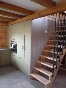 a staircase in a kitchen with white cabinets at Przystanek Ładnówko in Kruszyny Szlacheckie +16 photos